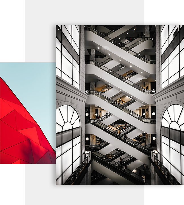 A striking indoor view of a multi-level shopping mall with white zigzagging escalators and large arched windows, overlapping a close-up of a vibrant red geometric building facade against a clear blue sky.